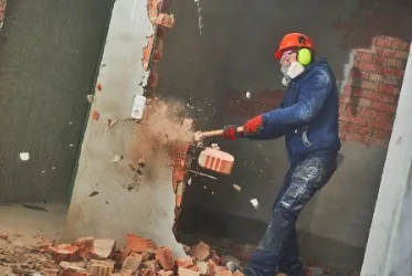 Mann reißt Wand ein